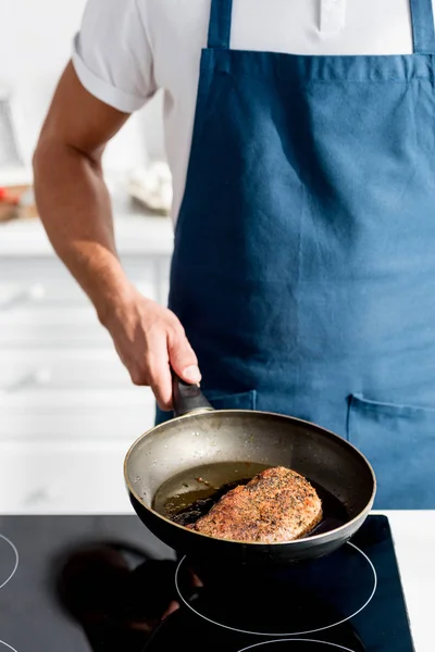 Partial view of man holding pan with cooked steak — Stock Photo