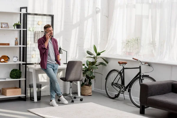 Man speaking on phone at home office — Stock Photo