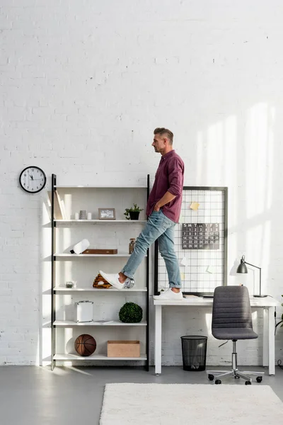 Man stepping from desk at home office — Stock Photo