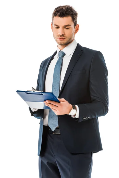 Concentrated businessman in suit looking at clipboard isolated on white — Stock Photo