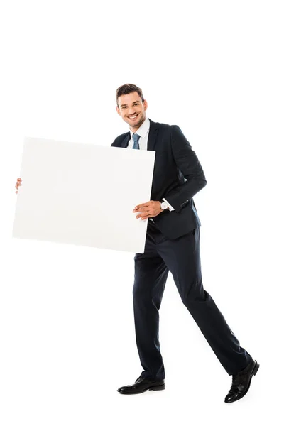 Smiling businessman in suit showing blank poster with copy space isolated on white — Stock Photo