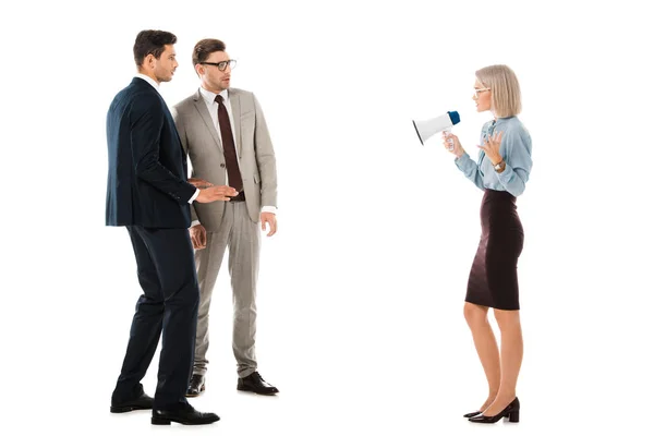 Dissatisfied businesswoman speaking in megaphone and looking at colleagues isolated on white — Stock Photo