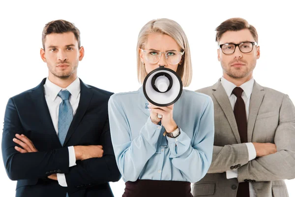 Angry businesswoman shouting in megaphone while colleagues standing with arms crossed isolated on white — Stock Photo