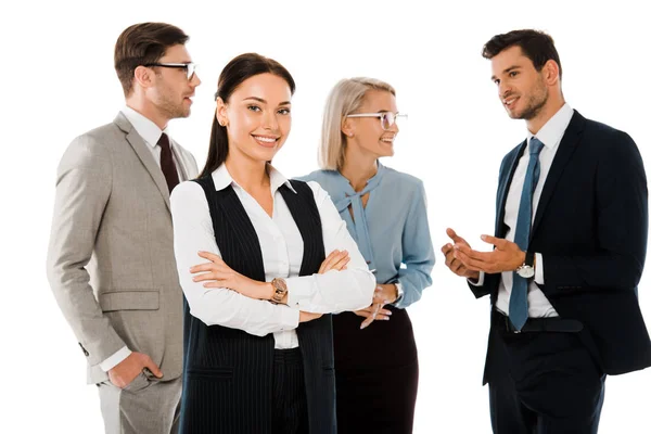Attractive successful businesswoman with crossed arms standing with professional colleagues isolated on white — Stock Photo