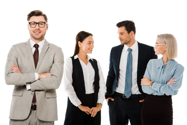 Successful businessman with crossed arms standing with professional colleagues isolated on white — Stock Photo