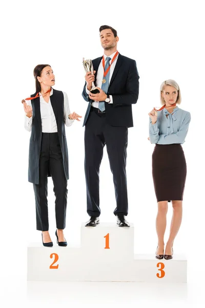 Businesspeople holding awards while standing on winners podium isolated on white — Stock Photo