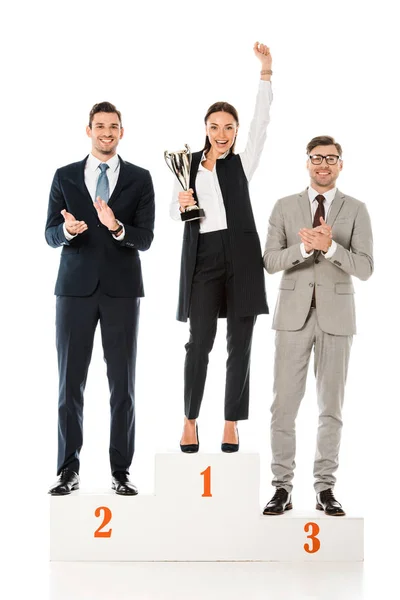 Professional businesspeople holding awards while standing on winners podium isolated on white — Stock Photo