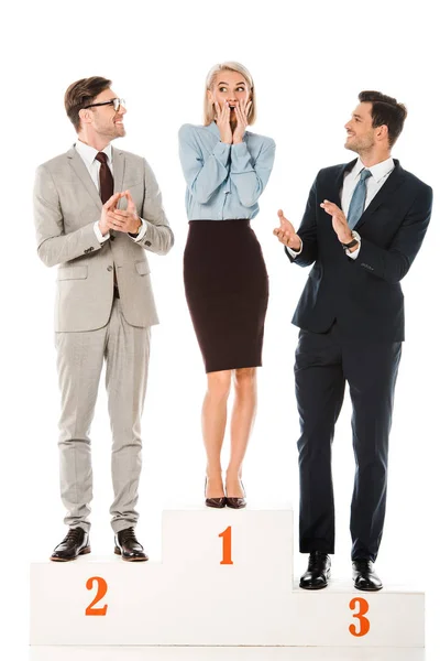 Empresários aplaudindo ao vencedor enquanto está em pé no pódio vencedores isolados em branco — Fotografia de Stock