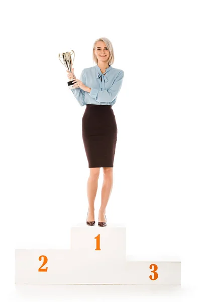 Donna d'affari di successo con coppa trofeo in piedi sul podio dei vincitori isolato sul bianco — Foto stock
