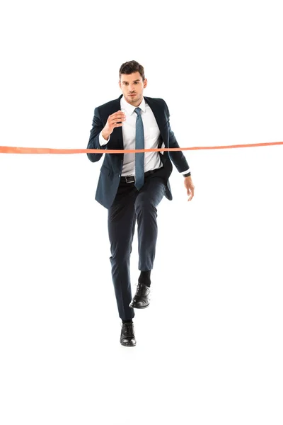 Handsome businessman in suit running to finishing line isolated on white — Stock Photo