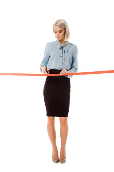 Beautiful businesswoman cutting red ribbon with scissors for grand opening, isolated on white — Stock Photo