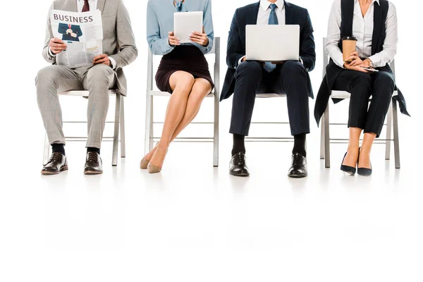 Unterschnitt-Ansicht von Geschäftsleuten, die auf Stühlen mit digitalen Geräten, Zeitung und Kaffeetasse sitzen, isoliert auf weiß — Stockfoto