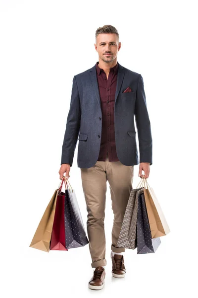 Hombre adulto con estilo en la chaqueta con bolsas de compras de colores aislados en blanco - foto de stock
