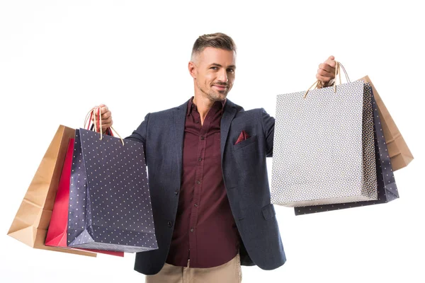 Adulte mâle shoppper en veste montrant des sacs en papier coloré isolé sur blanc — Photo de stock
