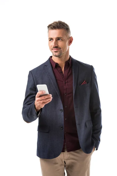 Усміхнений дорослий стильний чоловік в піджаку за допомогою смартфона ізольований на білому — стокове фото