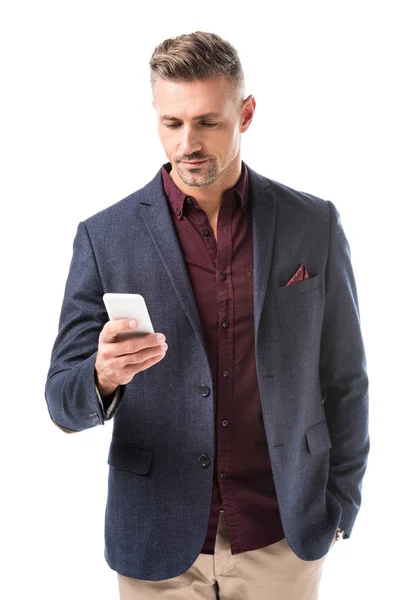 Focused adult stylish man in jacket using smartphone isolated on white — Stock Photo