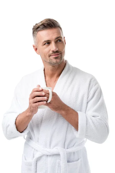 Hombre adulto feliz en albornoz sosteniendo taza de café aislado en blanco - foto de stock