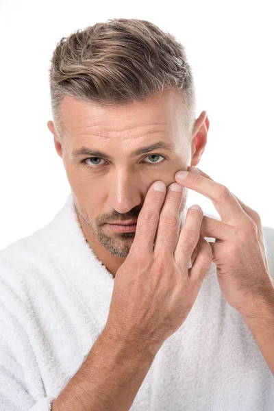 Serious adult man in bathrobe worrying about own appearance isolated on white — Stock Photo