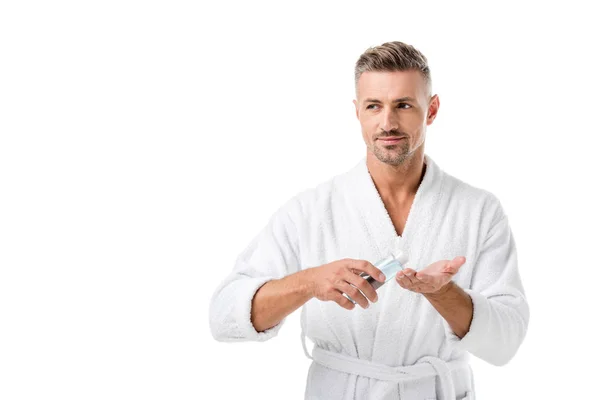 Взрослый мужчина в халате с использованием лосьона для бритья изолированы на белом — стоковое фото