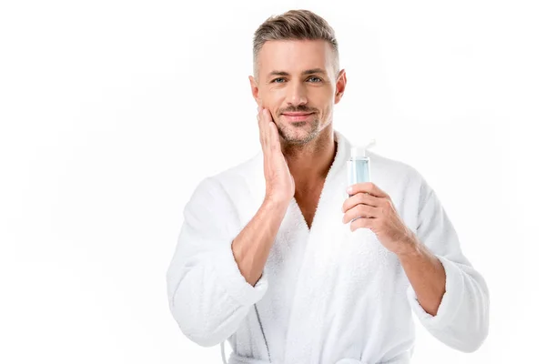 Retrato de hombre alegre en albornoz usando loción de afeitar aislado en blanco - foto de stock