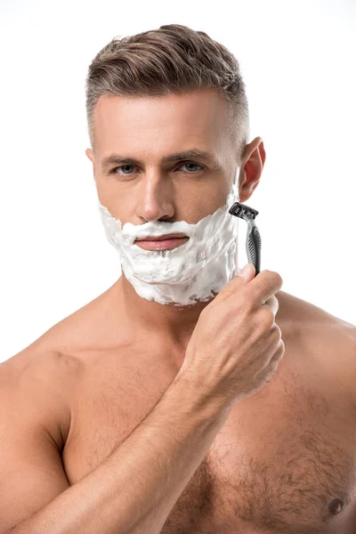 Confident man with foam on face shaving with razor isolated on white — Stock Photo