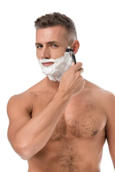 Hombre musculoso sin camisa con espuma en el afeitado facial con afeitadora aislada en blanco - foto de stock