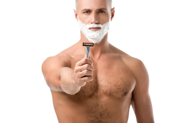 Man with shaving foam on face showing razor isolated on white — Stock Photo