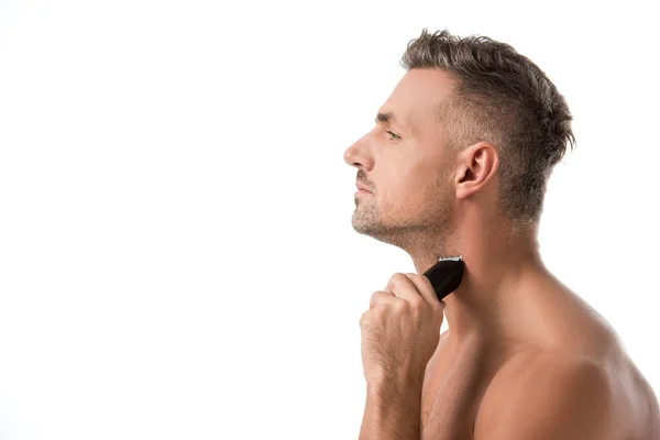 Seitenansicht des hübschen erwachsenen Mannes Rasur mit elektrischem Trimmer isoliert auf weiß — Stockfoto