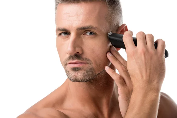 Портрет дорослого чоловіка, що голиться з електричним тримером ізольовано на білому — стокове фото