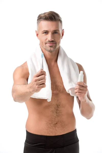 Веселий без сорочки дорослий чоловік показує зубну щітку ізольовано на білому — стокове фото