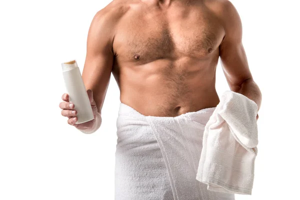 Image recadrée de l'homme torse nu musclé enveloppé dans une serviette tenant gel douche isolé sur blanc — Photo de stock