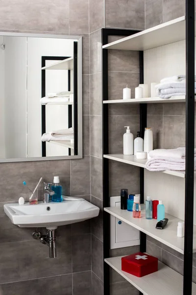 Intérieur de salle de bain moderne avec lavabos et étagères avec produits de beauté — Photo de stock