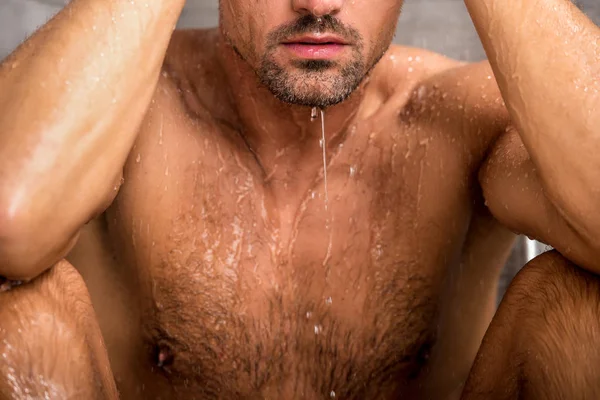 Imagem cortada do homem sentado sob o chuveiro durante o horário da manhã — Fotografia de Stock