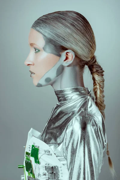 Visão lateral do cyborg prata futurista olhando para longe isolado no conceito de tecnologia cinza, futuro — Fotografia de Stock