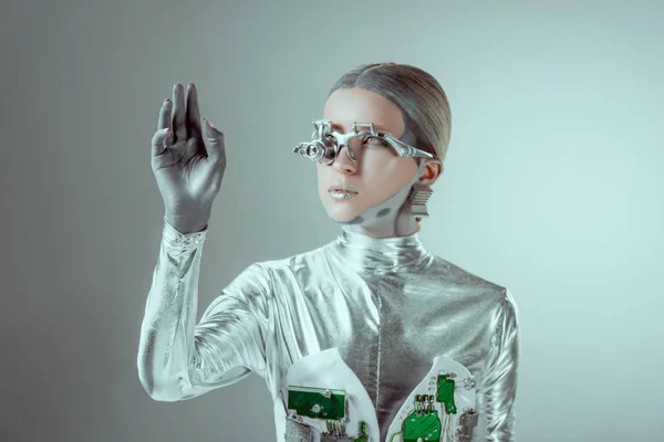 Futuristic silver robot gesturing with hand and looking away isolated on grey, future technology concept — Stock Photo