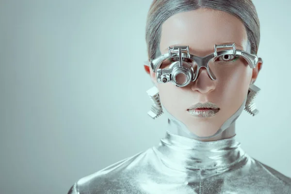 Visione ravvicinata del robot argento guardando la fotocamera isolata sul grigio, concetto di tecnologia futura — Foto stock