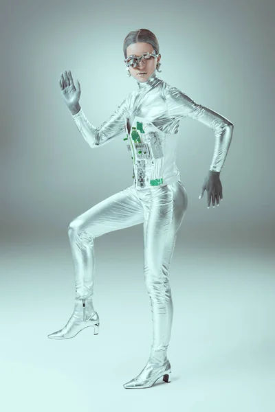 Full length view of futuristic cyborg walking and looking at camera on grey, future technology concept — Stock Photo