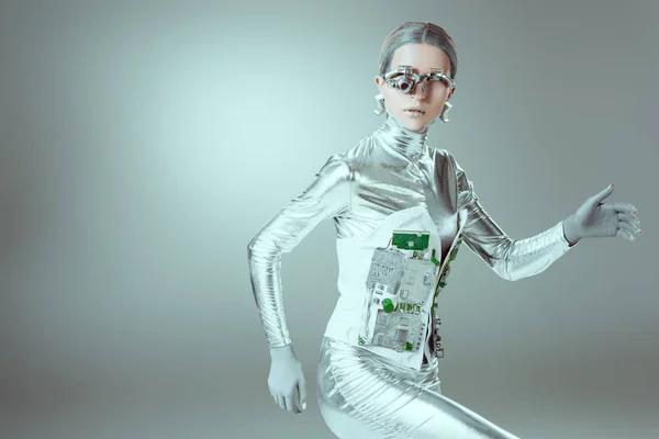Silver cyborg walking and looking at camera on grey, future technology concept — Stock Photo