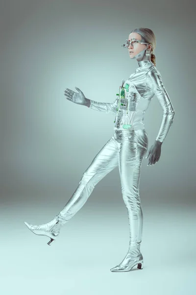 Side view of silver woman robot walking on grey, future technology concept — Stock Photo