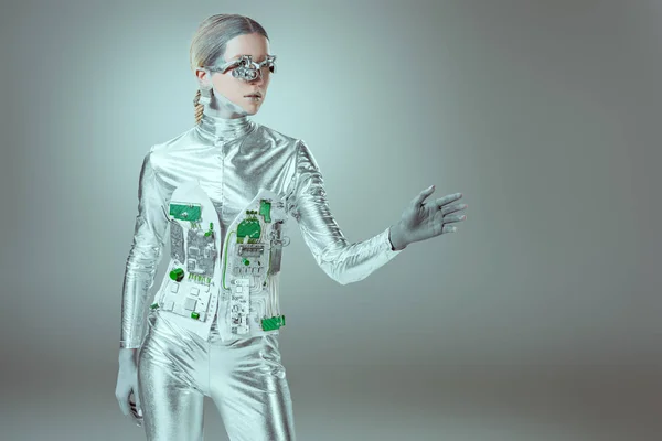 Silver woman robot gesturing with hand and looking away on grey, future technology concept — Stock Photo