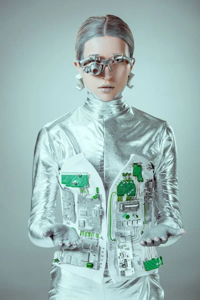 Futuristico robot d'argento che mostra le mani e guarda la fotocamera isolata sul grigio, concetto di tecnologia futura — Foto stock