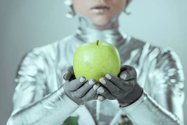 Primer plano vista parcial de cyborg sosteniendo manzana verde aislado en gris, futuro concepto de tecnología — Stock Photo