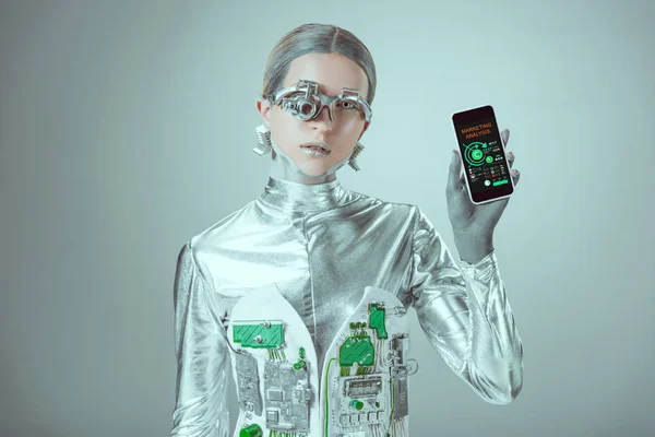 Robot tenant smartphone avec application d'analyse marketing et regardant la caméra isolée sur gris, concept technologique futur — Photo de stock