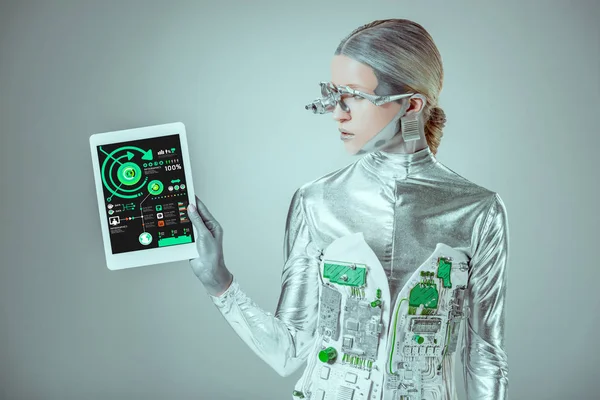 Robô de prata olhando para tablet com infográficos aparelho isolado em cinza, conceito de tecnologia futuro — Fotografia de Stock