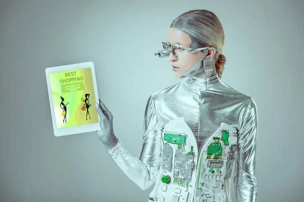 Robot argent regardant tablette avec le meilleur appareil commercial isolé sur gris, concept technologique futur — Photo de stock