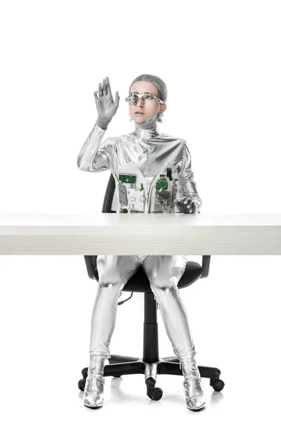 Cyborg assis à table et touchant quelque chose isolé sur blanc, concept technologique futur — Photo de stock