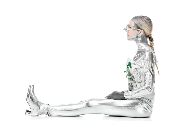 Vista laterale del robot d'argento seduto e guardando lontano isolato sul bianco, concetto di tecnologia futura — Foto stock