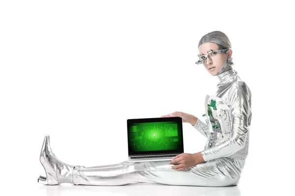 Robot argenté assis et montrant ordinateur portable avec appareil d'affaires isolé sur blanc, concept technologique futur — Photo de stock