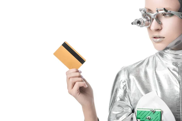 Silver robot looking at credit card isolated on white, future technology concept — Stock Photo