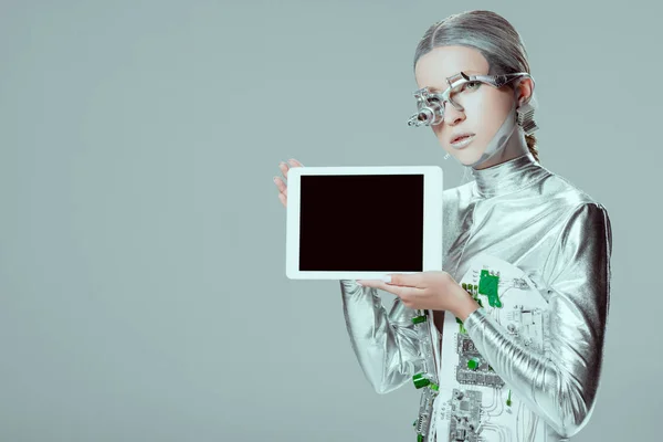 Silver robot holding tablet with blank screen isolated on grey, future technology concept — Stock Photo